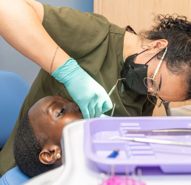 Dentist checking a patient's teeth during a dental exam in Mexico City.