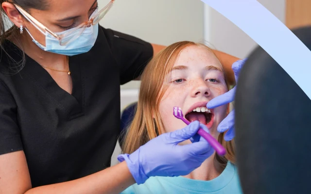 Dentist brushing a patient's teeth during a dental cleaning visit at hisonrisa in Roma Sur.