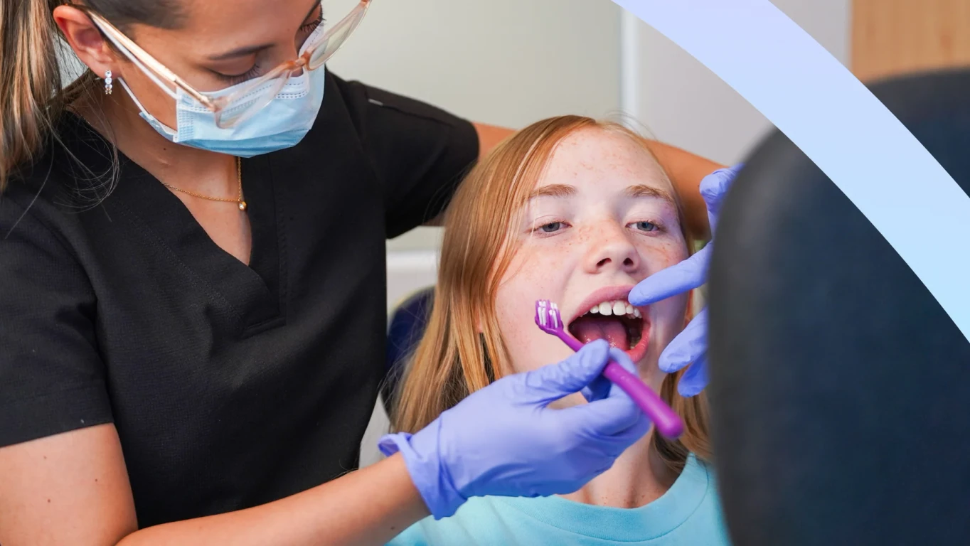 Dentist brushing a patient's teeth during a dental cleaning visit at hisonrisa in Roma Sur.