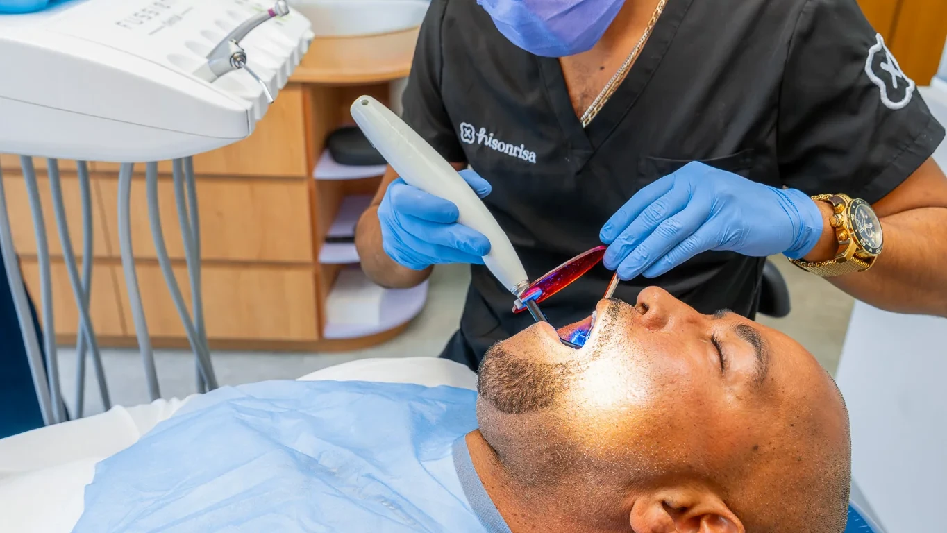 Dentist using a curing light during restorative care at hisonrisa in Mexico City.