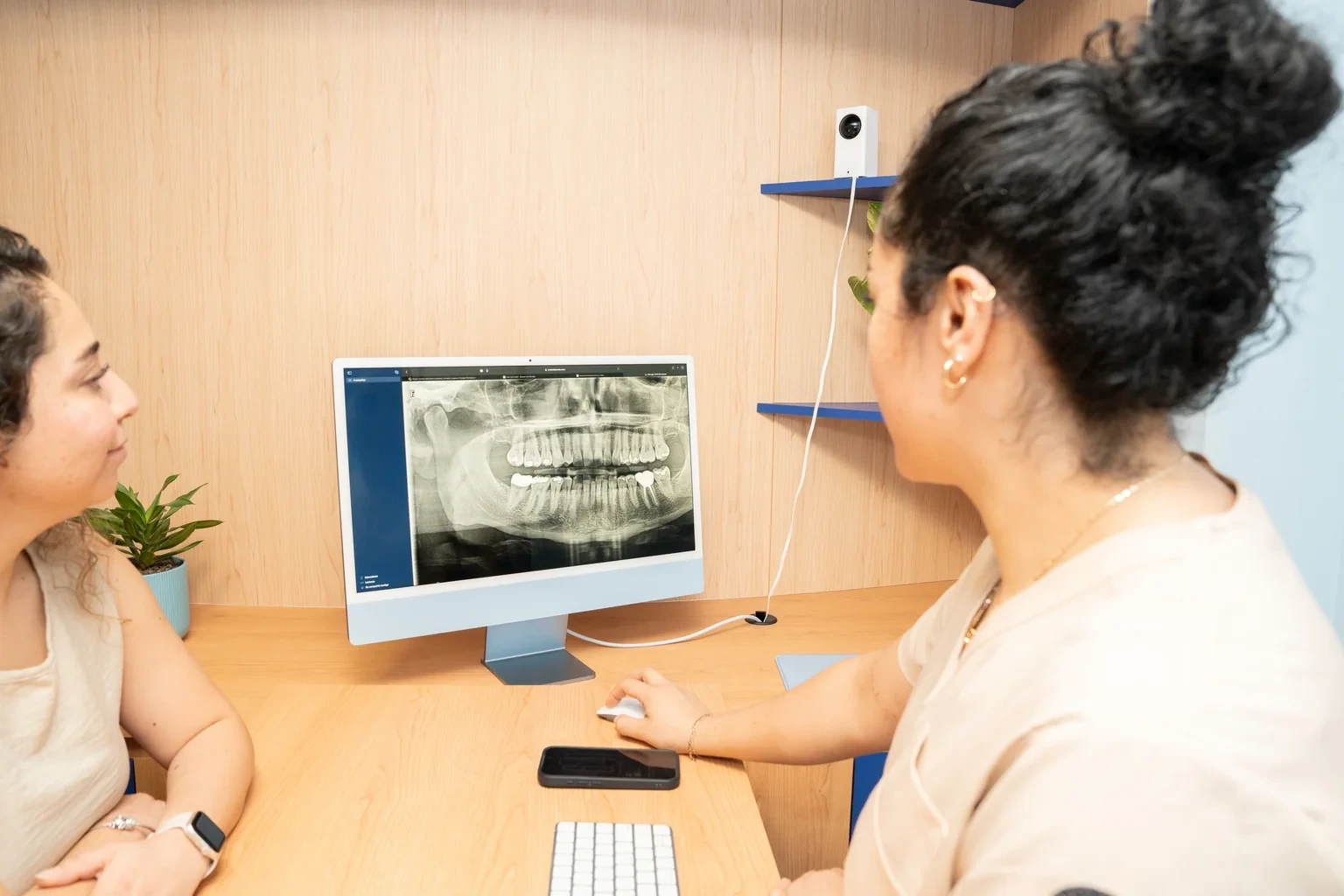 Clinician and patient reviewing a dental X-ray on a monitor during crown timing planning at hisonrisa.
