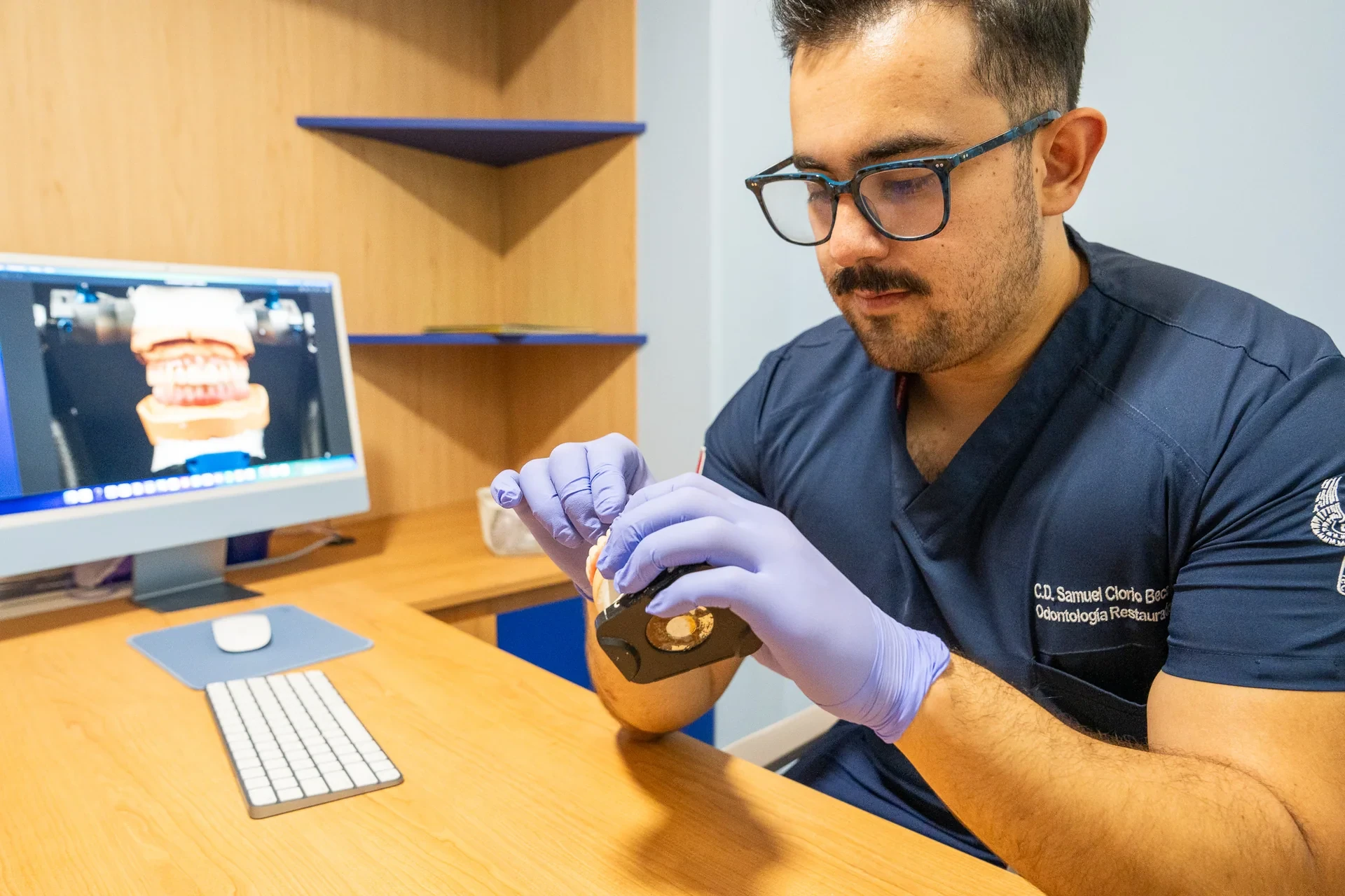 Clinician using a dental model to explain implant treatment stages during a planning appointment