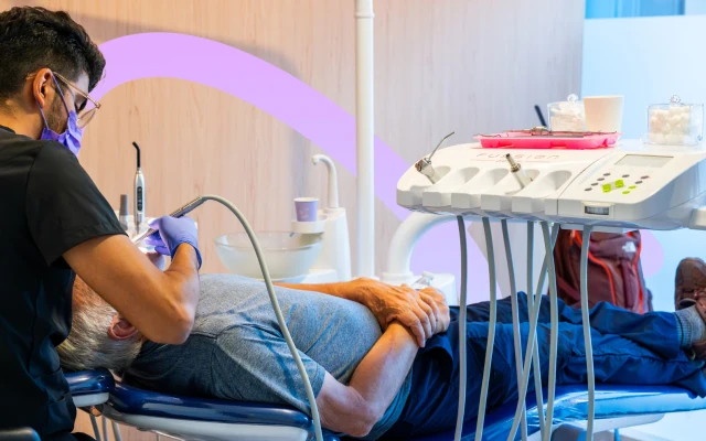 Dentist performing a dental cleaning procedure for a patient at hisonrisa in Roma Sur.