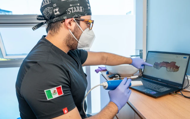Dentist reviewing an intraoral 3D scan on a laptop during implant planning at hisonrisa.