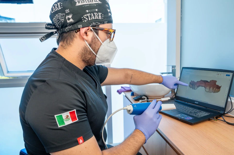 Dentist reviewing an intraoral 3D scan on a laptop during implant planning at hisonrisa.