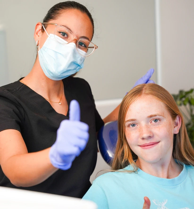 Dentist and young patient giving thumbs up after treatment at hisonrisa in Roma Sur, Mexico City.