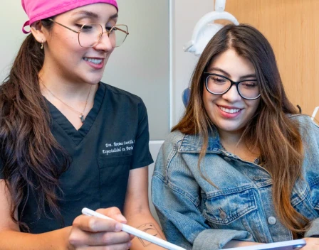 Dentist reviewing a treatment plan on a tablet with a patient at hisonrisa in Roma Sur, Mexico City.