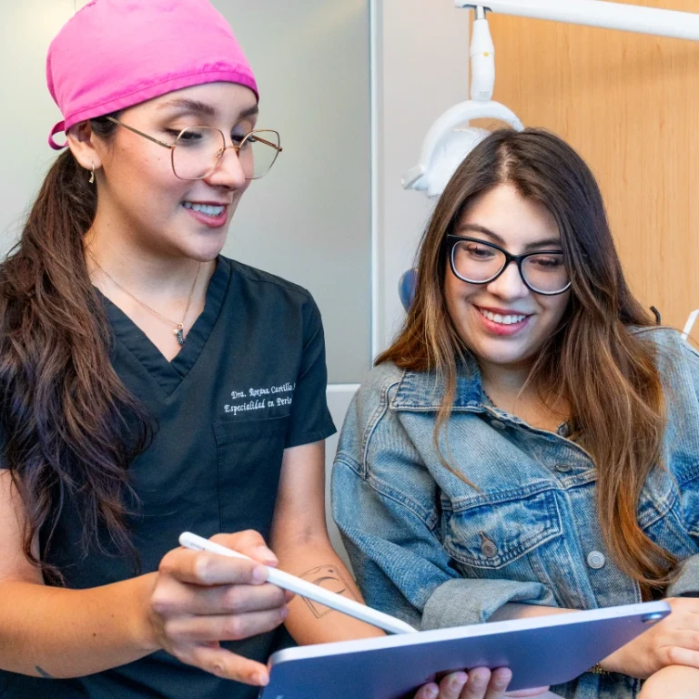 Dentist reviewing a treatment plan on a tablet with a patient at hisonrisa in Roma Sur, Mexico City.