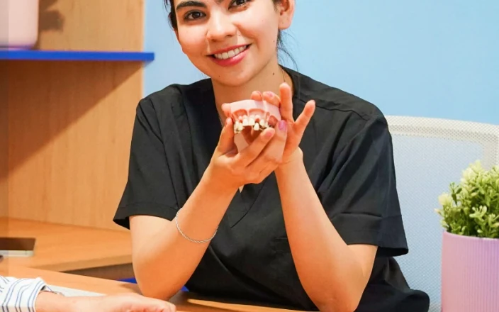 Dentist holding a dental model during a consultation at hisonrisa.