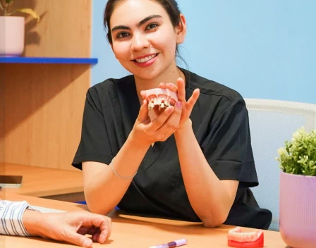 Dentist holding a dental model during a consultation at hisonrisa in Mexico City.