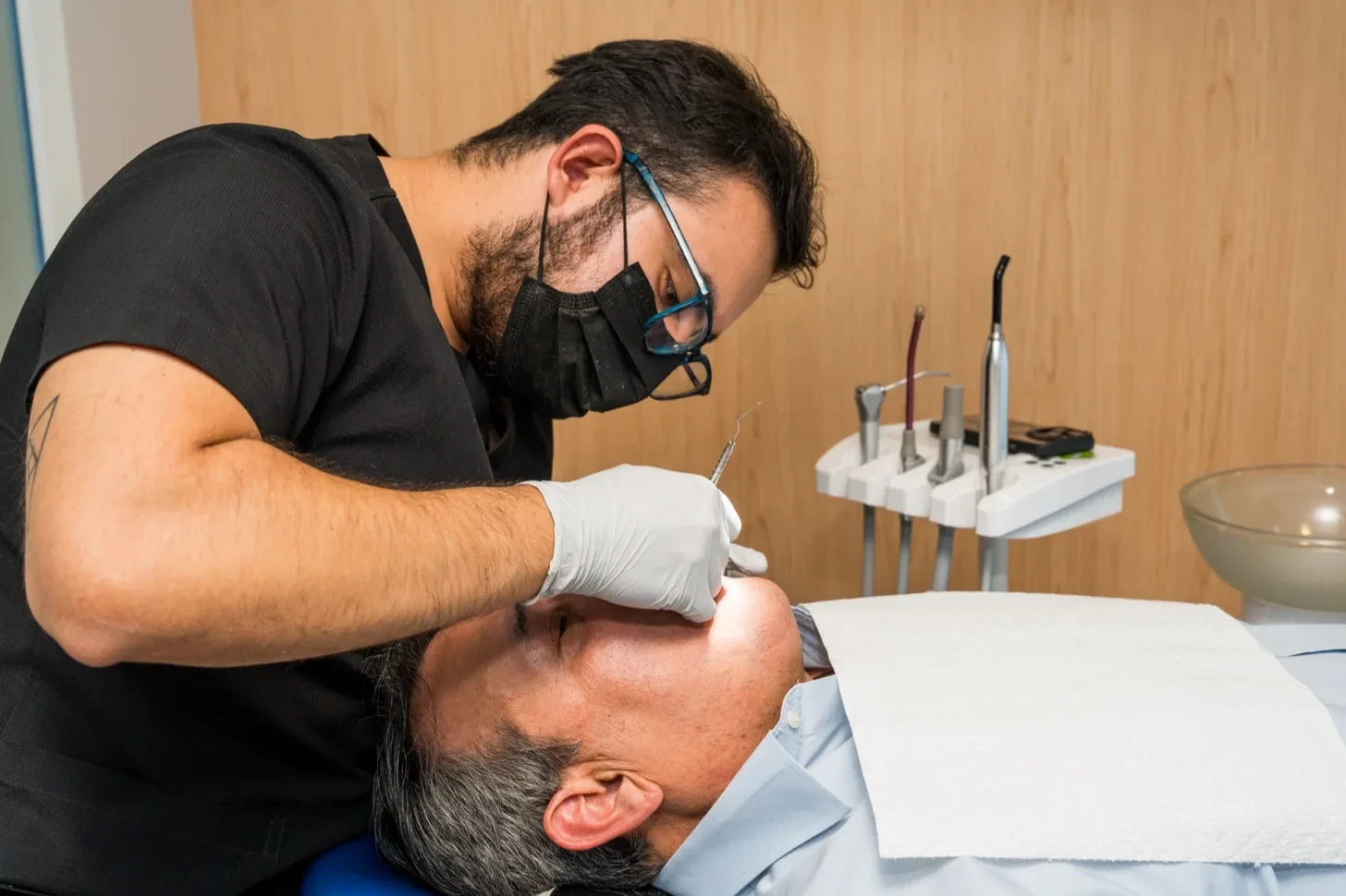 Dentist in gloves treating a patient in the chair at hisonrisa in Mexico City.