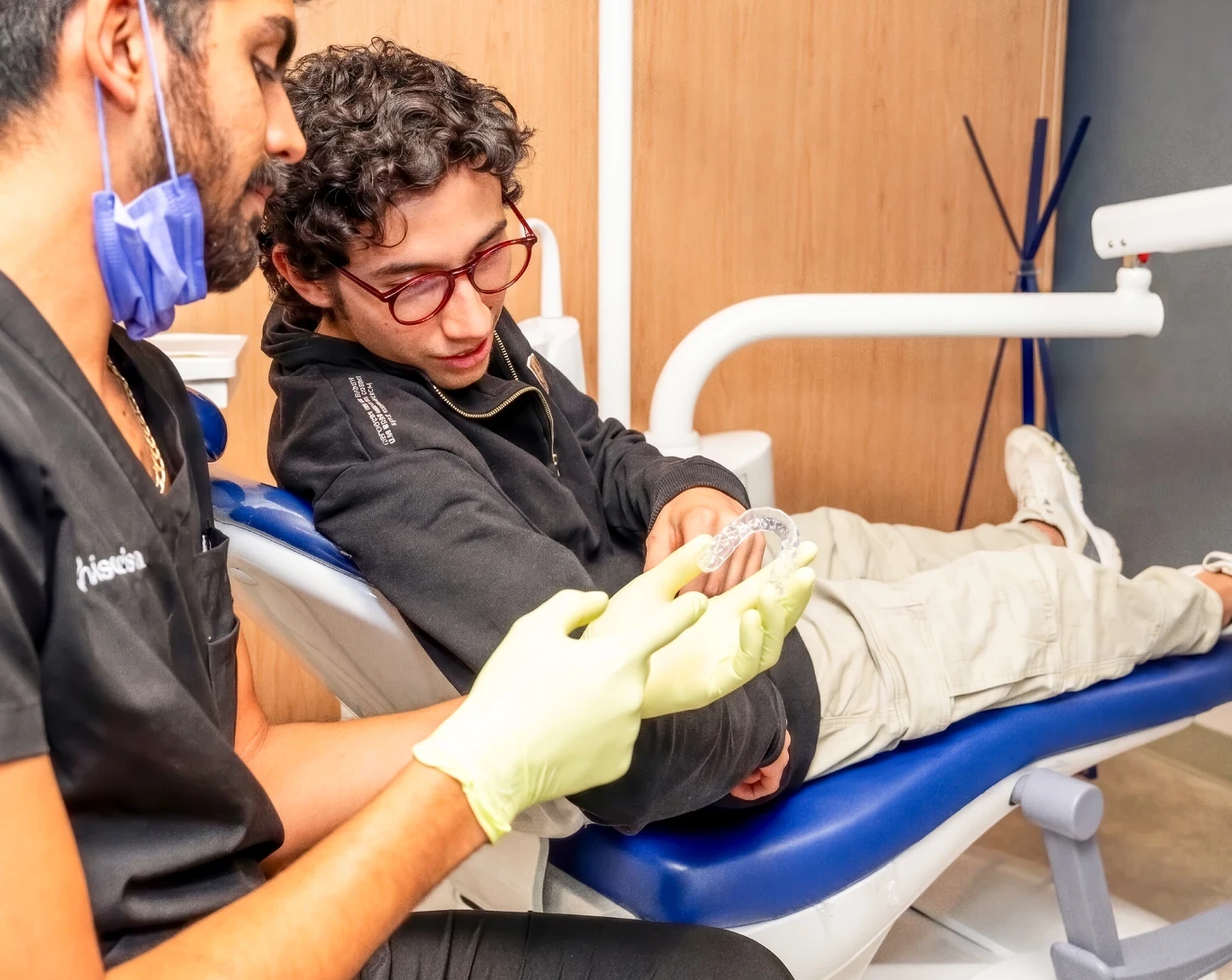 Dentist showing a custom night guard to a patient at hisonrisa in Roma Sur, Mexico City.