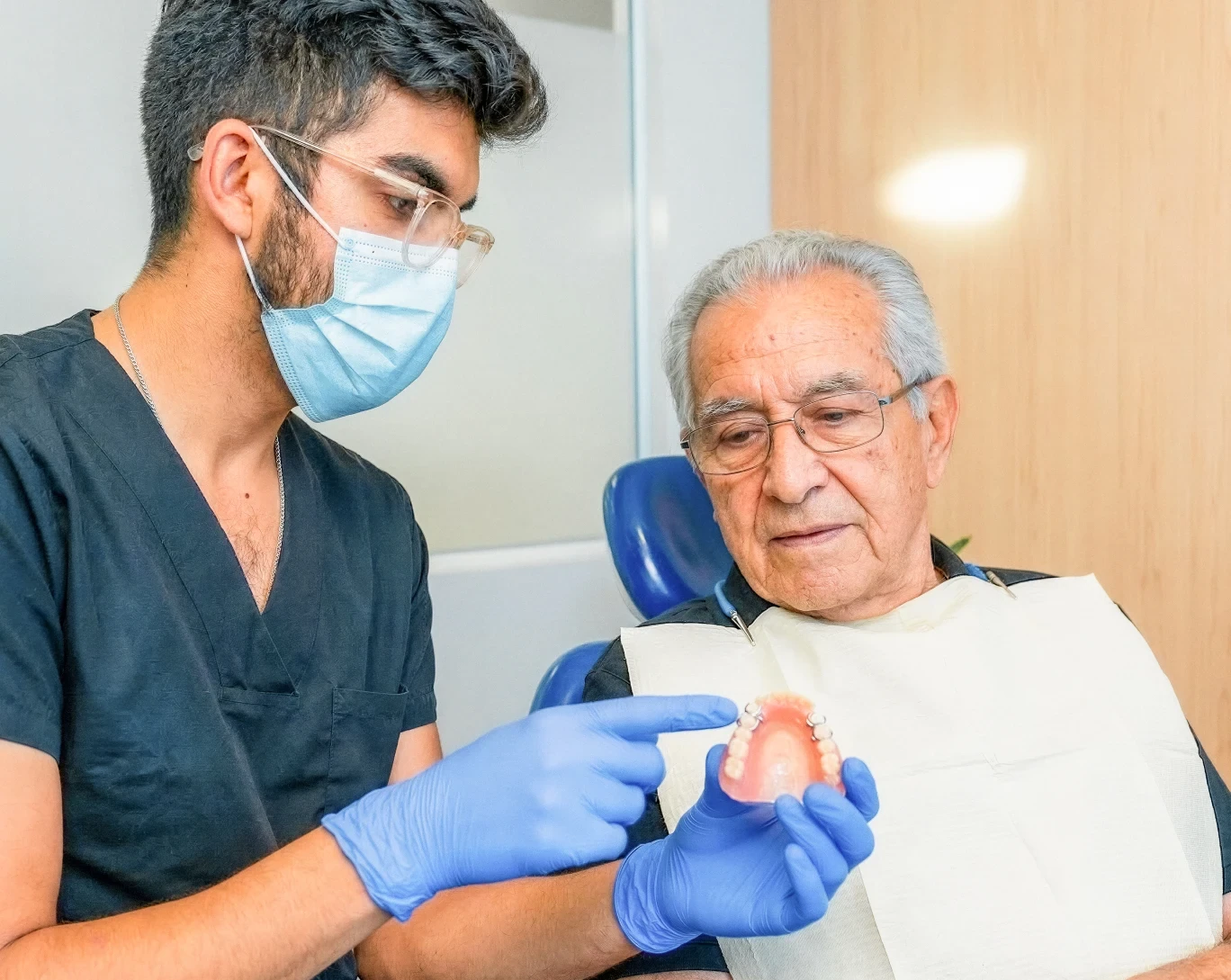 Dentist explaining a removable partial denture to a patient at hisonrisa in Roma Sur, Mexico City.