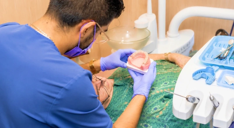 Dentist checking a removable denture model during lab planning.