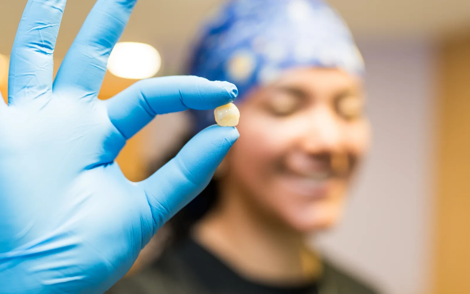 hisonrisa clinician holding a dental crown in a gloved hand in Mexico City.