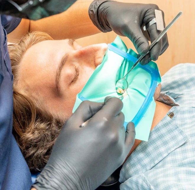 Dentist explaining root canal treatment tools to a patient in Mexico City.